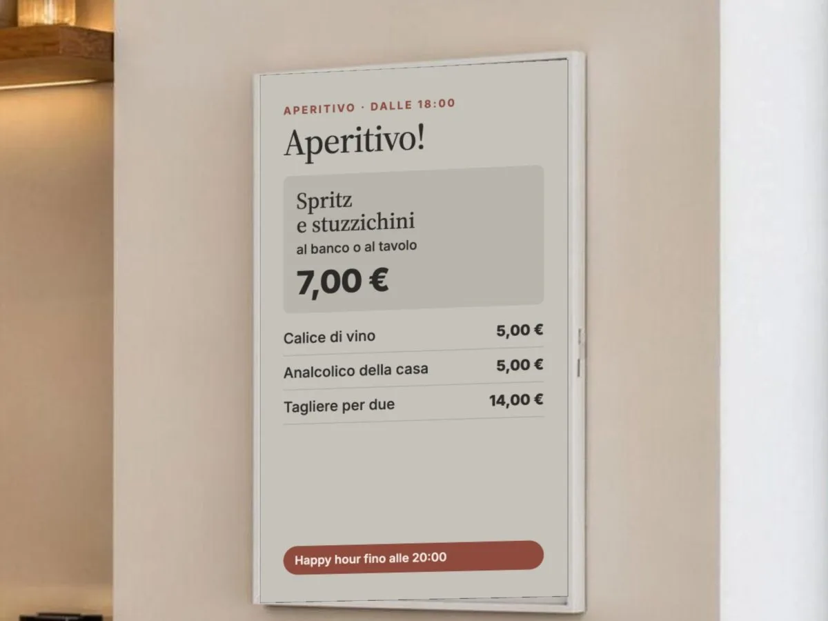 La stessa lavagna digitale alla parete del bar la sera, con l'aperitivo e gli stuzzichini