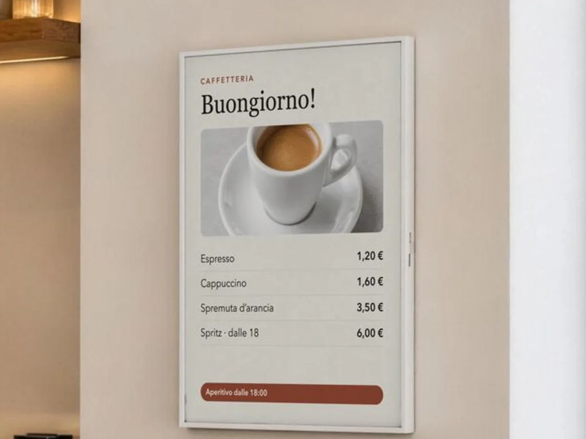 Lavagna digitale appesa alla parete di un bar con il listino della colazione: espresso, cappuccino e spremuta