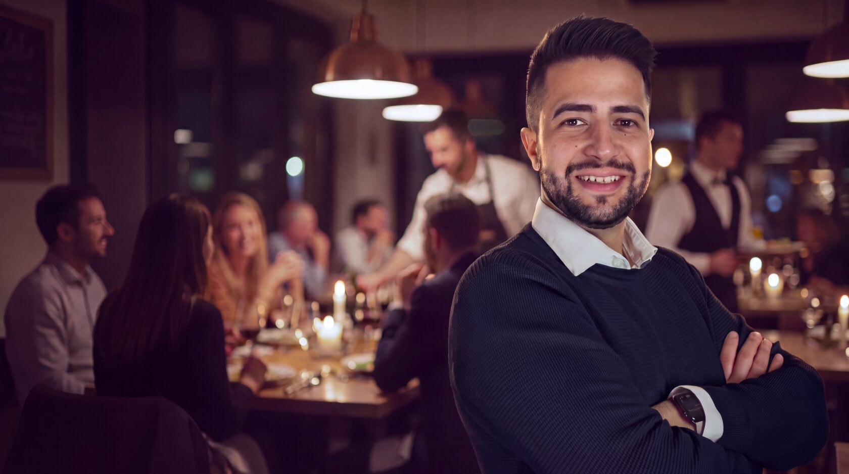 Cristian del team Intraweb, maglione blu, in un ristorante pieno di clienti